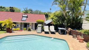 a swimming pool in front of a house at Yolonwabo Bed & Beakfast in East London