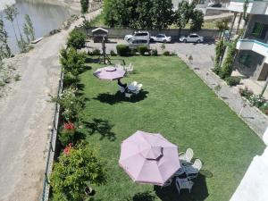 an overhead view of a garden with an umbrella and chairs at Hotel Blangsa Indus View in Skardu