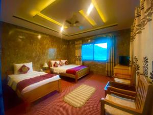 a hotel room with two beds and a window at Hotel Blangsa Indus View in Skardu