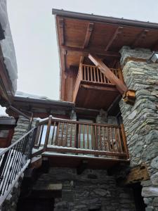 a wooden balcony on the side of a building at la casa del marmottaio in Crépin