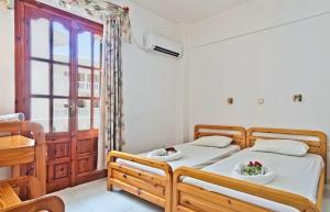 a bedroom with two beds and a window at Sea Stone Apartments in Karpathos