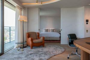 a bedroom with a bed and a chair and a desk at O'Ciel 24 - Exceptional 24th floor Residence - Ostend in Ostend