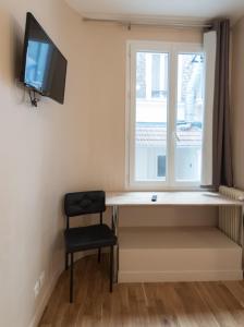 a room with a desk and a window and a chair at Hôtel De La Gare in Villeneuve-Saint-Georges