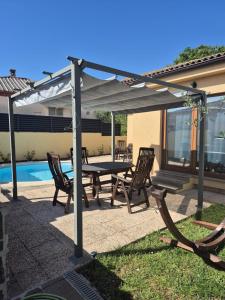 a patio with a table and chairs under an umbrella at Villa Aria in Marčana