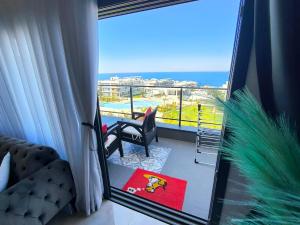 a room with a balcony with a view of the ocean at Luxury Sea & Pool View Apt at Caesar Cliff Esentepe in Perivolia tou Trikomou +3 photos