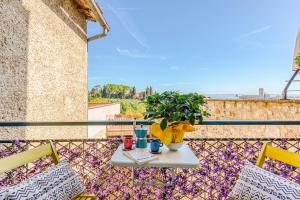 a table with two chairs and a plant on a balcony at Tuscan Treasure Tower in Colle di Val d'Elsa