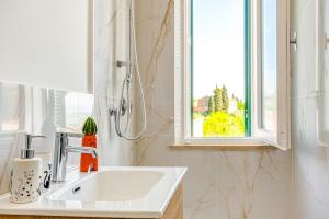 a white sink in a bathroom with a window at Tuscan Treasure Tower in Colle di Val d'Elsa