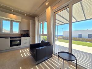 a kitchen with a couch and a table and some windows at Villas By George in Afiartis +57 photos