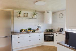 a kitchen with white cabinets and plants on shelves at Longbeach Life in Falkenberg