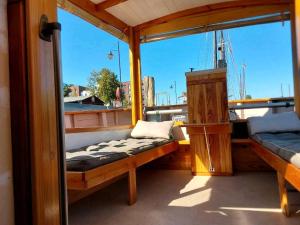 a porch of a boat with two benches on it at Boot Rosi Hafen Greiswald in Greifswald