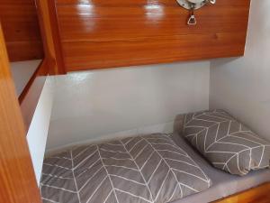 a bed in a room with a wooden cabinet at Boot Rosi Hafen Greiswald in Greifswald +7 photos