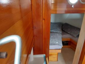a small room with a bed in a wooden cabinet at Boot Rosi Hafen Greiswald in Greifswald