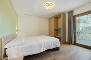 a bedroom with a bed and a large window at Appartamenti Suly 2 - Cir0083 in Saint Vincent