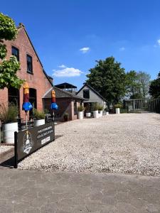 a building with a sign in the middle of a gravel driveway at Spoor 2 met Wellness in Nieuwe Vaart