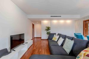 a living room with a couch and a tv at Modern 2 bedroom apt 20 min from city center in Amadora