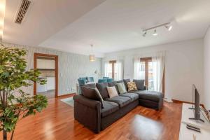 a living room with a couch and a television at Modern 2 bedroom apt 20 min from city center in Amadora