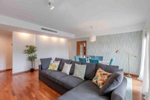 a living room with a gray couch and blue chairs at Modern 2 bedroom apt 20 min from city center in Amadora