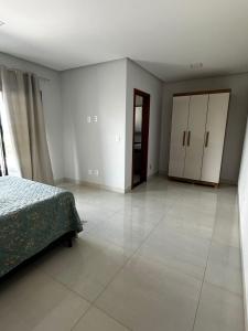 a bedroom with a bed and a large tile floor at Sobrado amplo com churrasqueira in Rio Verde