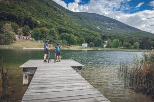 two people standing on a dock with bikes on a lake at Casa Edoardo in Cavedine