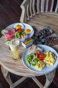 a table with two plates of food and a drink at Campuan Sari Villa in Ketewel