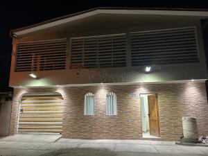 a brick building with a garage and a window at Hostal sol del norte in Paipote