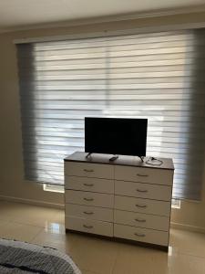 a tv on top of a dresser in front of a window at Hostal sol del norte in Paipote