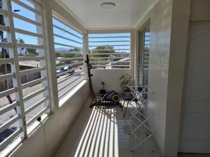 a room with a balcony with windows and a table at Hostal sol del norte in Paipote