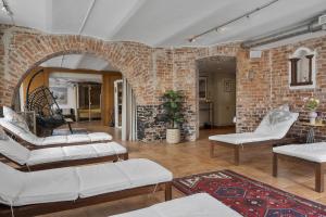 a living room with white furniture and a brick wall at Hotel Continental Relax & Spa, BW Signature Collection in Halmstad