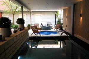 a swimming pool in a house with chairs and a table at Hotel Continental Relax & Spa, BW Signature Collection in Halmstad