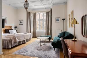 a bedroom with a bed and a table and a couch at Hotel Continental Relax & Spa, BW Signature Collection in Halmstad +141 photos