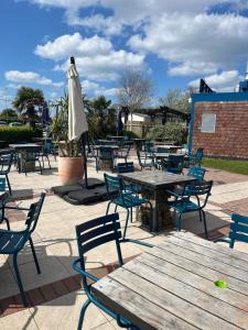 a patio with tables and chairs and an umbrella at Haven Caravan Park Cala Gran 3 bedrooms Fleetwood in Fleetwood