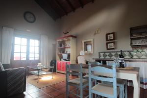 a living room with a table and a dining room at Casa Rural la Hojalata in Mocanal