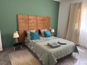 a bedroom with a large bed with blue pillows at Villa Belle-Vue in Tabarka