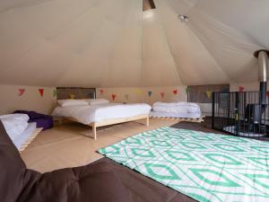 a room with two beds and a rug in a tent at YHA Castleton Losehill Hall in Castleton