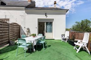 a patio with a table and chairs on the grass at Gîte La Salamandre in Mosnes +16 photos