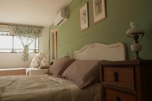 a bedroom with a bed and a couch and a window at Estancia Urbana Hotel Boutique in Río Cuarto