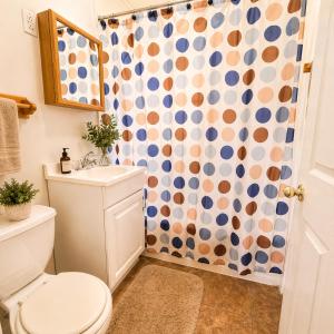 a bathroom with a toilet and a shower curtain at Buccaneer Bay Bungalow #6 in Sunrise Beach +5 photos