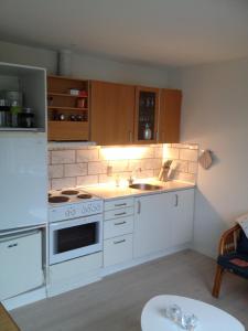 Sommerlyst في لوكين: مطبخ مع موقد أبيض ومغسلة