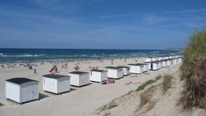 uma praia com um monte de casas de banho portáteis em Sommerlyst em Lokken