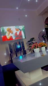 a room with a table and two vases of flowers at Kash apartments in Diani Beach