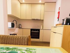 a kitchen with white cabinets and a stove top oven at Refúgio Brisa Mar in Vila do Conde