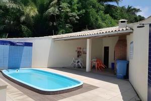 a swimming pool on a patio next to a house at Apartamento Ilhéus próximo à praia in Ilhéus