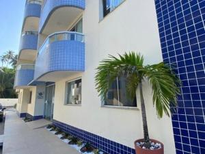 a palm tree in a pot next to a building at Apartamento Ilhéus próximo à praia in Ilhéus