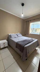 a bedroom with a bed and a window at Apartamento Ilhéus próximo à praia in Ilhéus