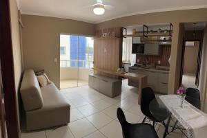 a kitchen and living room with a couch and a table at Apartamento Ilhéus próximo à praia in Ilhéus +5 photos