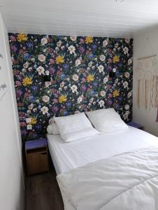 a bedroom with a floral patterned wall behind a bed at Mobilhome rénove climatisé - 10min plage - Mimizan in Mimizan