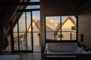 a bath tub in a room with two windows at Villa Real Chalés in Viçosa do Ceará