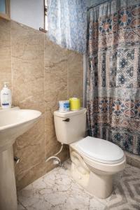 a bathroom with a toilet and a sink and a shower curtain at Serenity Escape, Cozy Stay w Secure Parking in Runaway Bay
