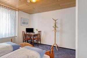 a bedroom with two beds and a table with a computer at Hotel Garni Siedlerstube 2 in Nürtingen +95 photos
