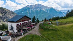 a building on a hill with mountains in the background at Hôtel Chalet Sainte-Anne in Condamine-Châtelard +28 photos